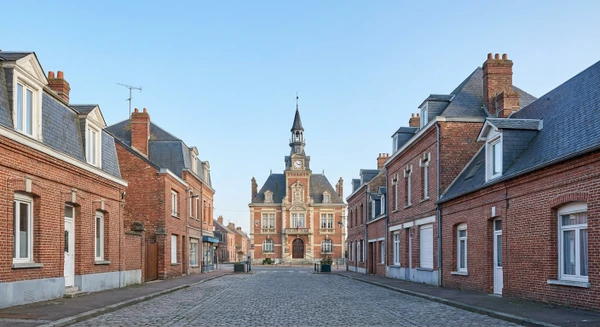 Photographie r&eacute;aliste de la ville de Tergnier en Aisne montrant une perspective urbaine ou architecturale caract&eacute;ristique&nbsp;: vue d'une rue principale, fa&ccedil;ades de b&acirc;timents typiques de la commune, point de rep&egrave;re local ou paysage urbain repr&eacute;sentatif de Tergnier en Picardie. L'image doit &ecirc;tre une photographie authentique sans personnes au premier plan, prise de jour en conditions naturelles, repr&eacute;sentant clairement l'identit&eacute; visuelle de cette commune.